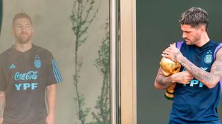 Rodrigo de Paul acaricia la copa ante la mirada desde lejos de Lionel Messi.