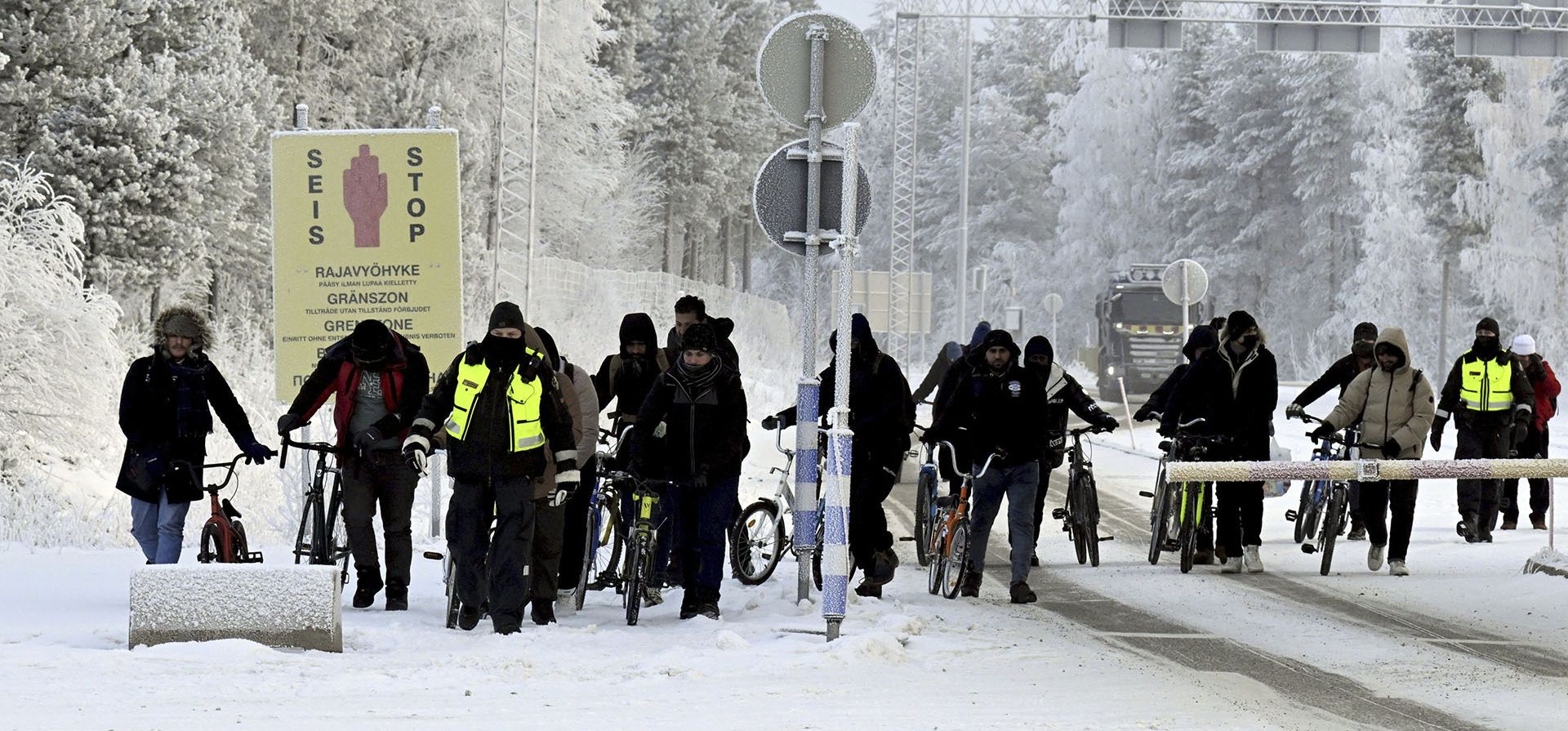 Guardias fronterizos finlandeses, con chalecos amarillos, escoltan a inmigrantes en bicicletas en el cruce fronterizo internacional de Salla, al norte de Finlandia, el martes 21 de noviembre de 2023. (Jussi Nukari/Lehtikuva vía AP) Guardias fronterizos finlandeses, con chalecos amarillos, escoltan a inmigrantes en bicicletas en el cruce fronterizo internacional de Salla, al norte de Finlandia, el martes 21 de noviembre de 2023. (Jussi Nukari/Lehtikuva vía AP)
