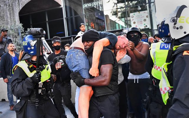 Un manifestante lleva a un contramanifestante herido a un lugar seguro cerca de la estación de Waterloo de Londres durante una protesta de Black Lives Matter en junio de 2020. Fotografía: Dylan Martinez / Reuters
