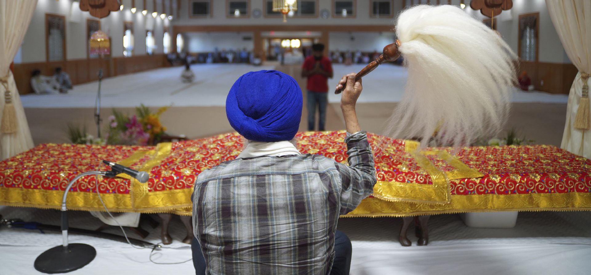 Un hombre agita el Chaur Sahib, rindiendo respeto a las sagradas escrituras, durante la oración vespertina en Gurdwara Millwoods, una casa de culto sij, en Edmonton, Alberta.
