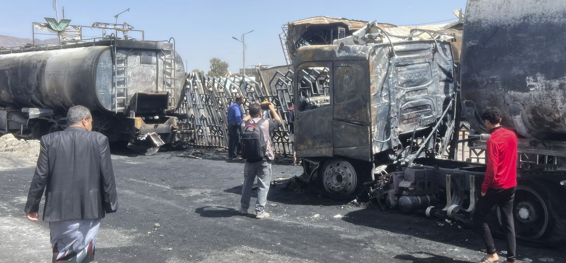 Personas observan vehículos y edificios dañados un día después de los ataques aéreos israelíes contra la principal gasolinera en Saná, Yemen, el lunes 25 de agosto de 2025. (Foto AP) Personas observan vehículos y edificios dañados un día después de los ataques aéreos israelíes contra la principal gasolinera en Saná, Yemen, el lunes 25 de agosto de 2025. (Foto AP)