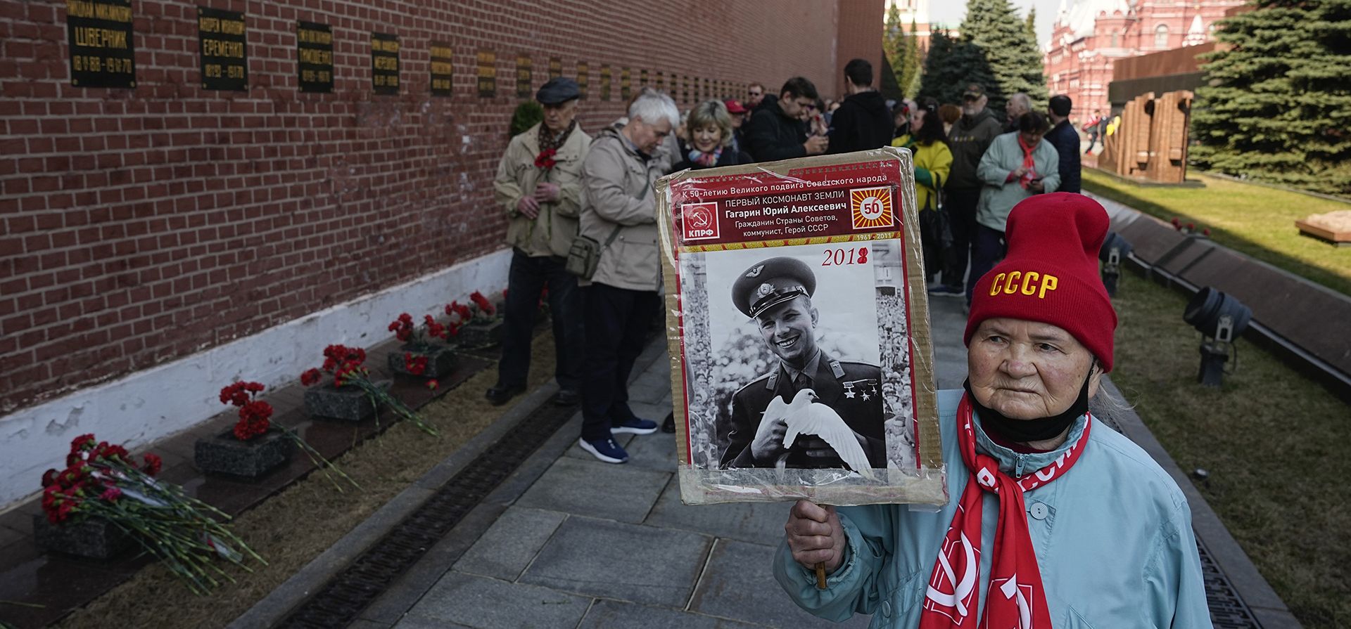 Una anciana lleva un retrato de Yuri Gagarin, el cosmonauta que se convirtió en la primera persona en el espacio cuando los partidarios del partido comunista depositaron flores en su tumba en el muro del Kremlin en la Plaza Roja, para conmemorar el 62 aniversario de su vuelo en Moscú, Rusia, el miércoles. 12 de abril de 2023. (Foto AP/Alexander Zemlianichenko)