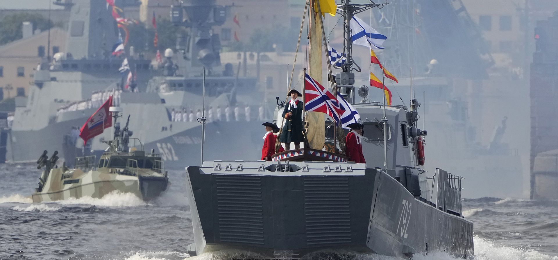 Un buque de guerra transporta una copia del barco del zar ruso Pedro el Grande, en el río Neva, durante un ensayo del desfile naval en San Petersburgo, Rusia, el jueves 28 de julio de 2022.