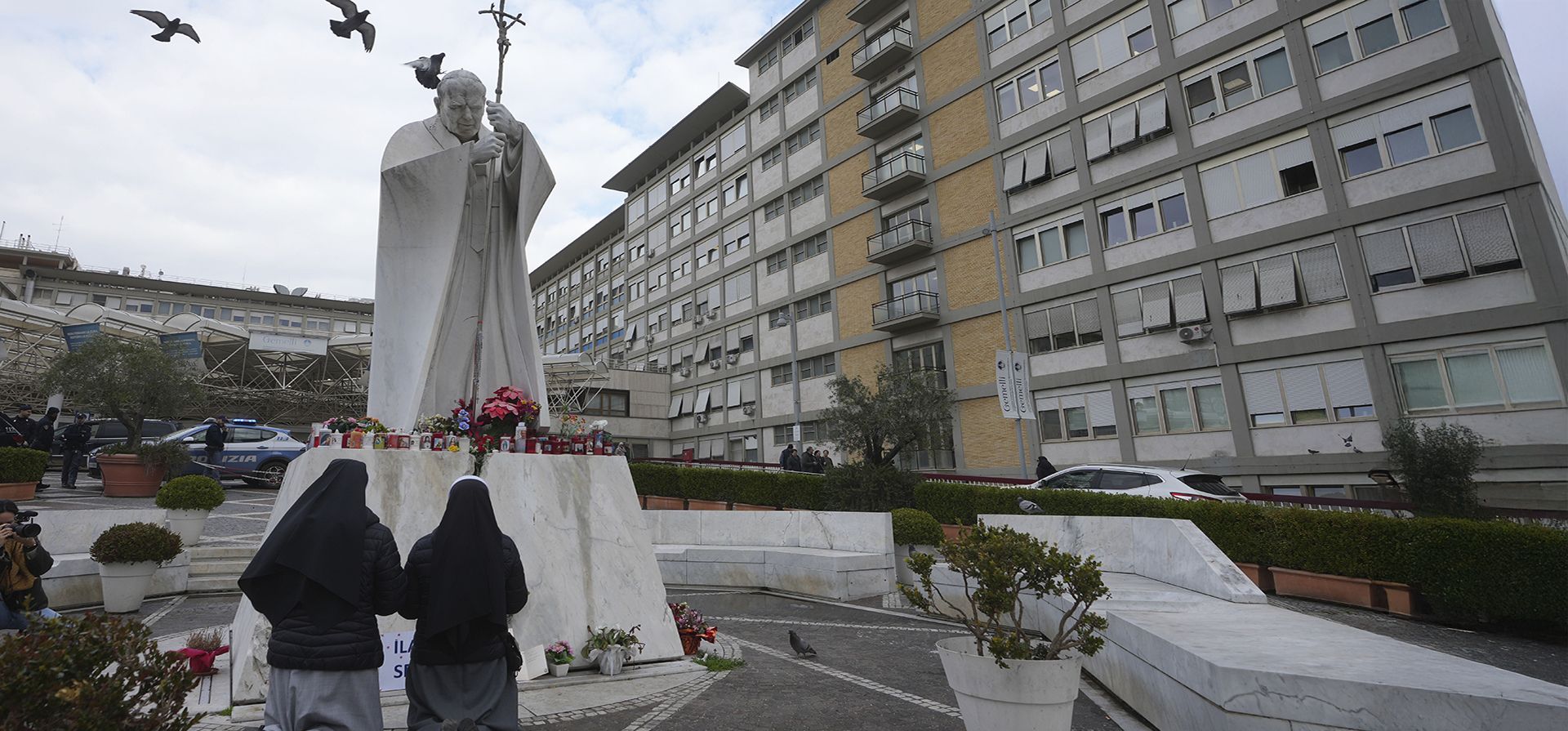 Monjas rezan por el papa Francisco frente a la estatua del papa Juan Pablo II en el Policlínico Agostino Gemelli, en Roma, el jueves 20 de febrero de 2025, donde el pontífice está hospitalizado desde el viernes 14 de febrero. (Foto AP/Alessandra Tarantino)