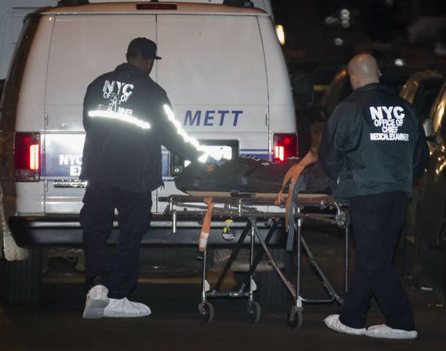 Una madre y cuatro hijos. Funcionarios retiran uno de los cinco muertos en el distrito neoyorquino de Brooklyn.