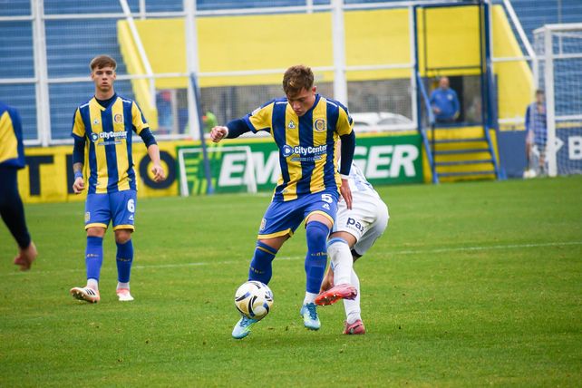El volante central Lucas Ramos cubre el balón frente a la marca del jugador de Racing.