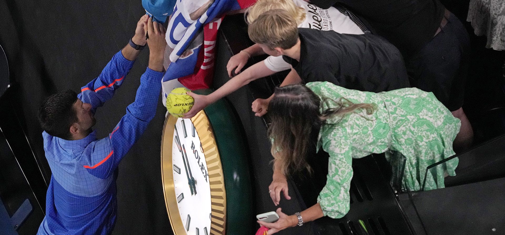El serbio Novak Djokovic firma autógrafos luego de su victoria en la cuarta ronda sobre Alex de Minaur de Australia en el campeonato de tenis del Abierto de Australia en Melbourne, Australia, el lunes 23 de enero de 2023. (AP Foto/Dita Alangkara)