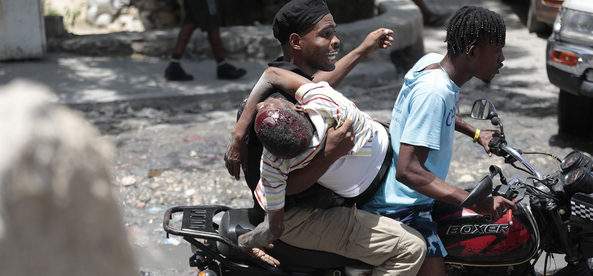 Un agente de policía sostiene a un hombre herido de bala en la cabeza durante choques violentos entre pandillas mientras lo llevan en mototaxi en el distrito Carrefour-Feuilles de Puerto Príncipe, Haití. (AP Foto/ Odelyn Joseph) Un agente de policía sostiene a un hombre herido de bala en la cabeza durante choques violentos entre pandillas mientras lo llevan en mototaxi en el distrito Carrefour-Feuilles de Puerto Príncipe, Haití. (AP Foto/ Odelyn Joseph)