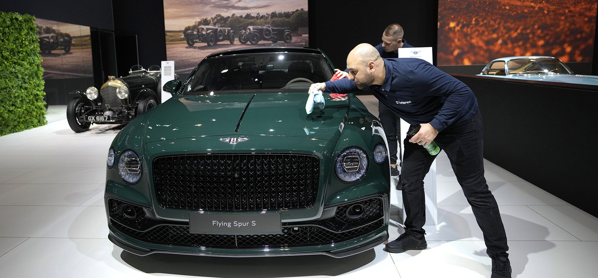 Un asistente pule un Bentley Flying Spur S durante la apertura de medios del Salón del Automóvil de Bruselas, 13 de enero de 2023. (Foto AP/Virginia Mayo)