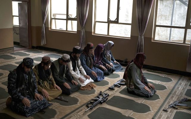 Combatientes afganos se detienen en una mezquita local para rezar en Kabul, Afganistán.