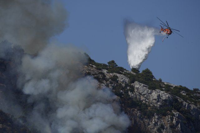 Combate a&eacute;reo contra las llamas que asedian a Atenas desde hace casi una semana. El desastre en la capital griega fue iniciado por un hombre que provoc&oacute; tres focos intencionales, seg&uacute;n las autoridades.