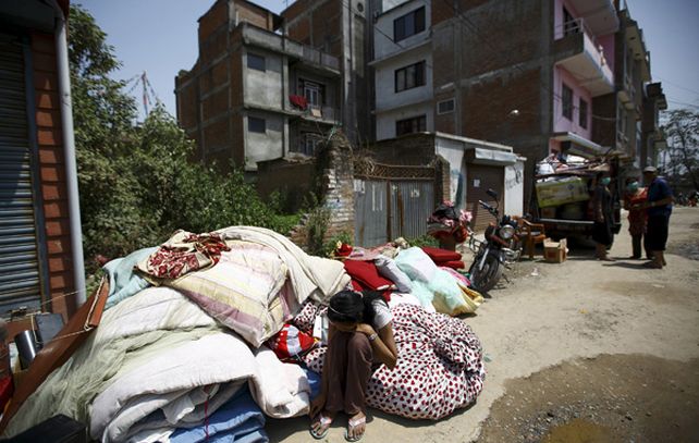 Una joven descansa sobre varios colchones apilados en una calle de Kathmandu. (Foto: Reuters)