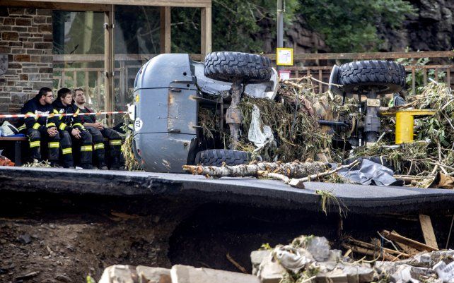 Bomberos se toman un descanso en un banco en un pueblo en el distrito de Ahrweiler mientras lidian con la devastación causada por la inundación del río Ahr en el oeste de Alemania, el jueves 15 de julio de 2021.