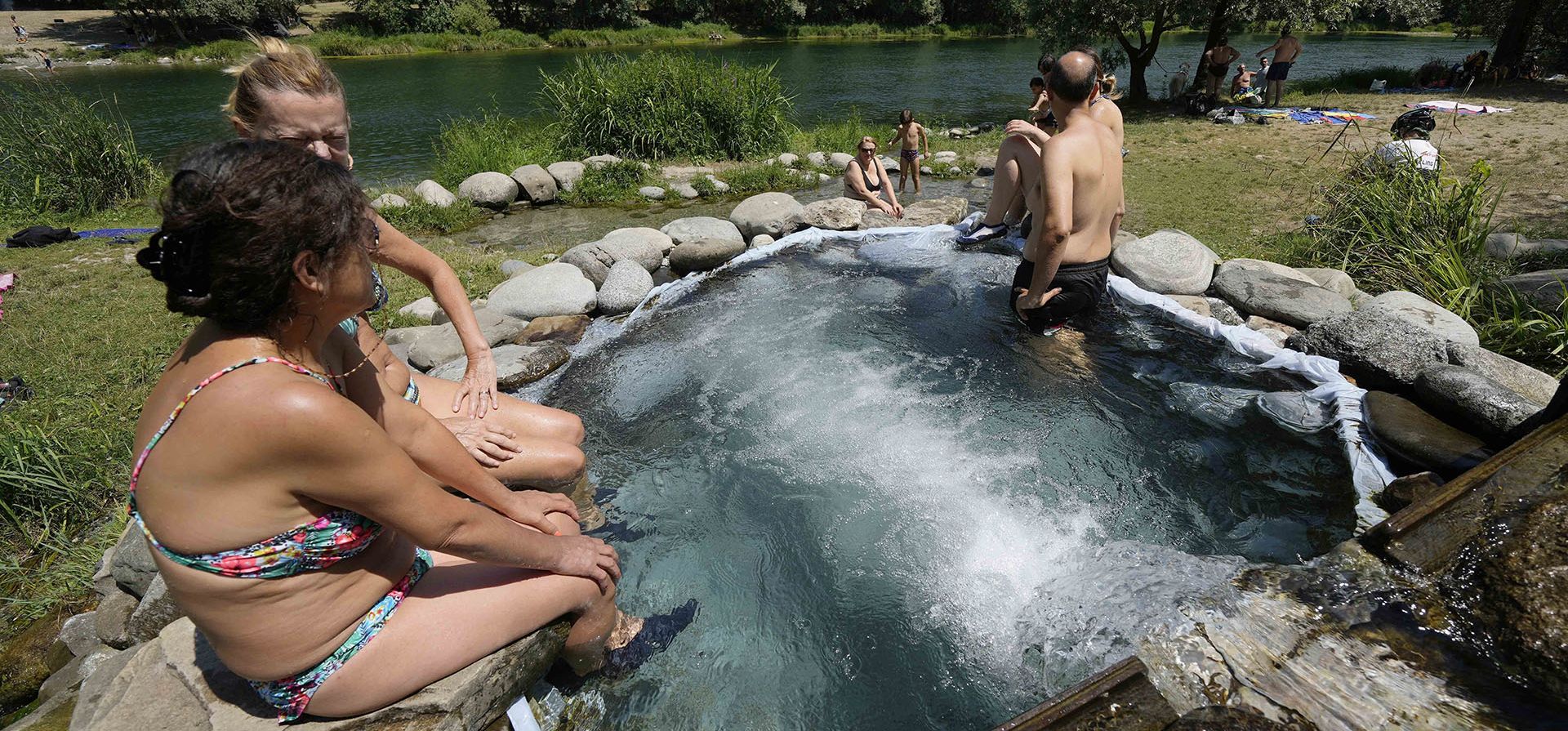 La gente se refresca en piscinas a orillas del río Adda, norte de Italia, en Cornate D