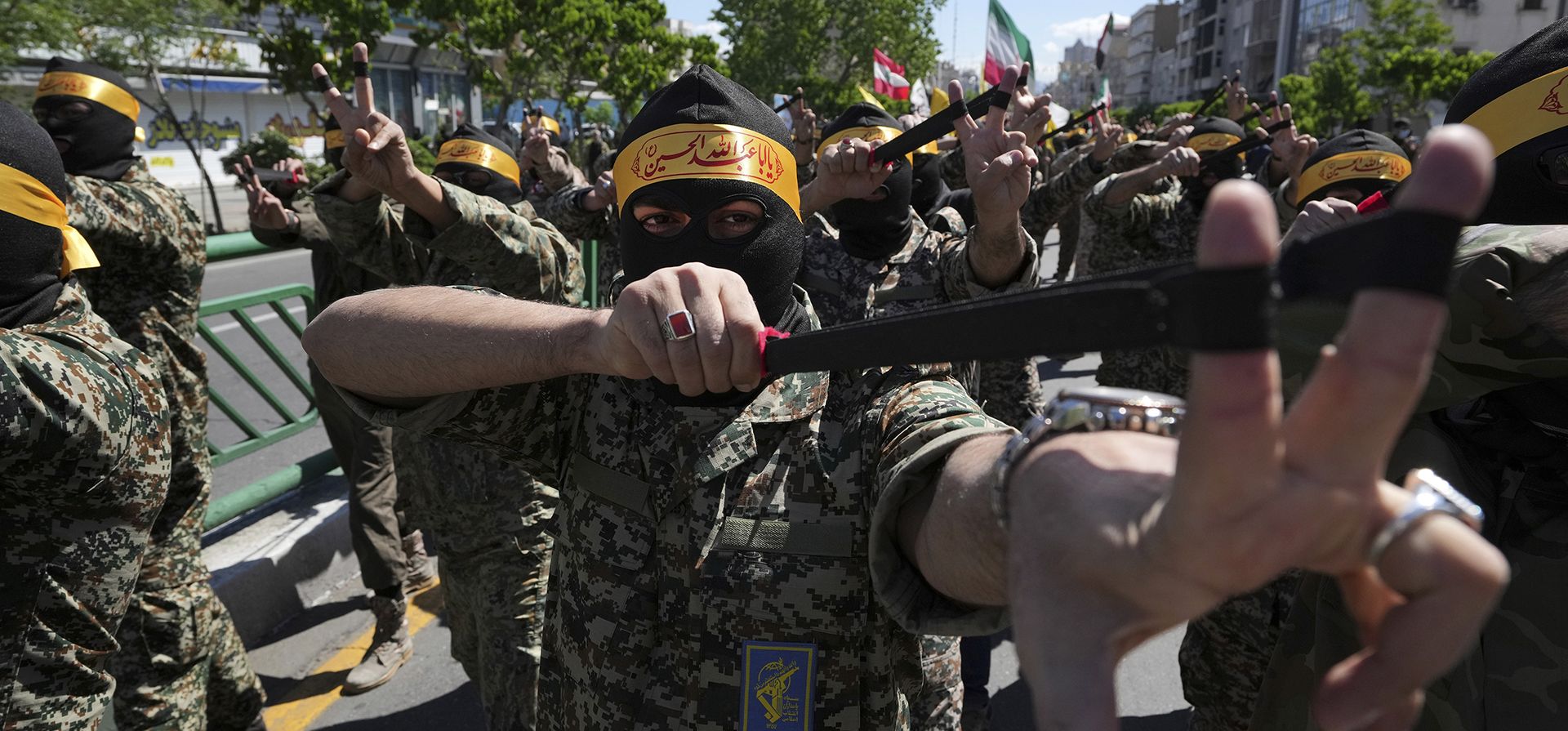 Miembros de la fuerza paramilitar iraní Basij usan simbólicamente una honda para mostrar a niños palestinos que se enfrentan a las fuerzas israelíes, en su manifestación para conmemorar el Día de Jerusalén, una muestra anual de apoyo a los palestinos, en Teherán, Irán, el viernes 14 de abril de 2023. (Foto AP /Vahid Salemi)
