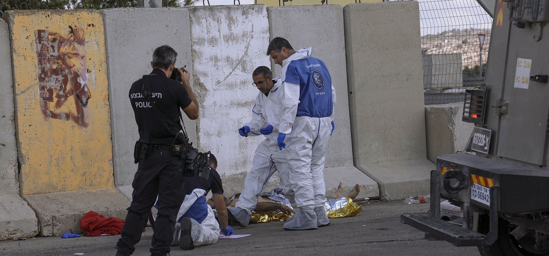 La policía israelí inspecciona el cuerpo de un atacante palestino en el lugar del atentado automovilístico en el puesto de control de Maccabim en Cisjordania, cerca del asentamiento israelí de Beit Horon, el miércoles 2 de noviembre de 2022. Un palestino estrelló su automóvil contra un oficial del ejército israelí en un puesto de control en Cisjordania.