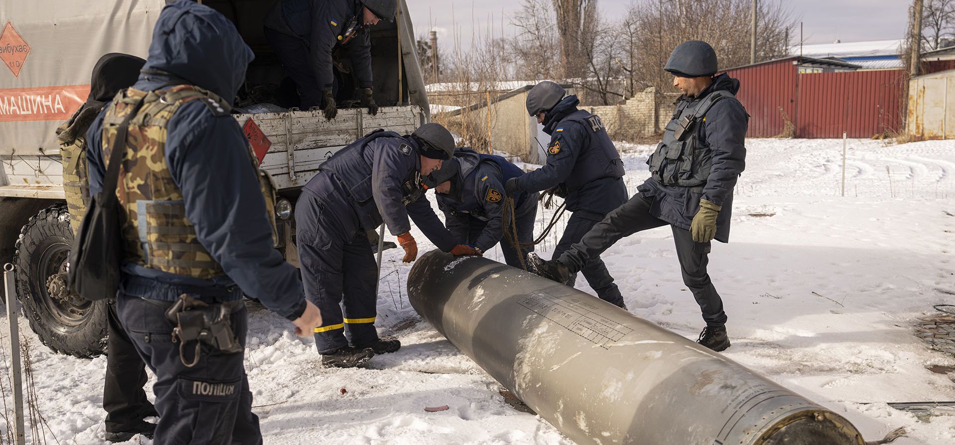 Empleados de los servicios de emergencia se preparan para cargar los restos de un misil S-300 disparado por las fuerzas rusas en un camión en Kharkiv, Ucrania, el viernes 17 de febrero de 2023. (Foto AP/Vadim Ghirda)