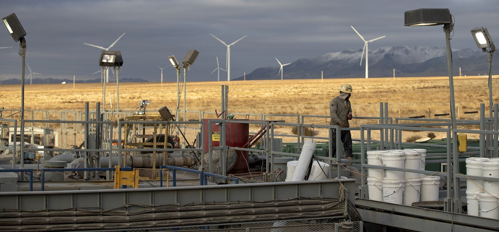 Un operador de plataforma camina por un sitio de perforación geotérmica de Fervo Energy cerca de Milford, Utah, con un parque eólico al fondo. En Nevada, el primer proyecto geotérmico operativo de Fervo Energy ha comenzado a bombear electricidad libre de carbono a la red eléctrica de ese estado para alimentar los centros de datos de Google, anunció Google el martes 28 de noviembre. (Foto AP/Ellen Schmidt) Un operador de plataforma camina por un sitio de perforación geotérmica de Fervo Energy cerca de Milford, Utah, con un parque eólico al fondo. En Nevada, el primer proyecto geotérmico operativo de Fervo Energy ha comenzado a bombear electricidad libre de carbono a la red eléctrica de ese estado para alimentar los centros de datos de Google, anunció Google el martes 28 de noviembre. (Foto AP/Ellen Schmidt)