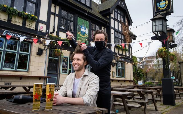 Un cliente recibe un corte de pelo gratis en una peluquería emergente. Millones de personas en Inglaterra tendrán su primera oportunidad en meses para cortarse el pelo
