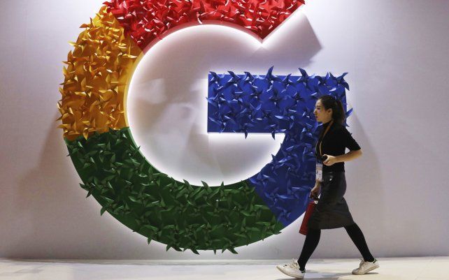Una mujer pasa junto al logotipo de Google en la Exposición Internacional de Importaciones de China en Shanghai. El organismo de control anticompetitivo de Francia ha decidido multar a Google con 220 millones de euros por abusar de su 