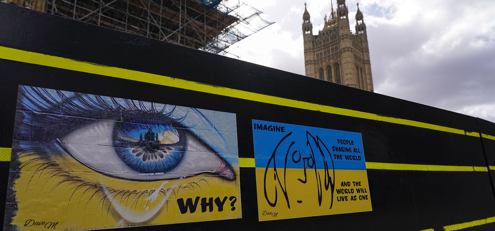 Imágenes pegadas con la bandera de Ucrania colocadas en las barreras frente al Parlamento británico en Londres, el jueves 7 de abril de 2022.