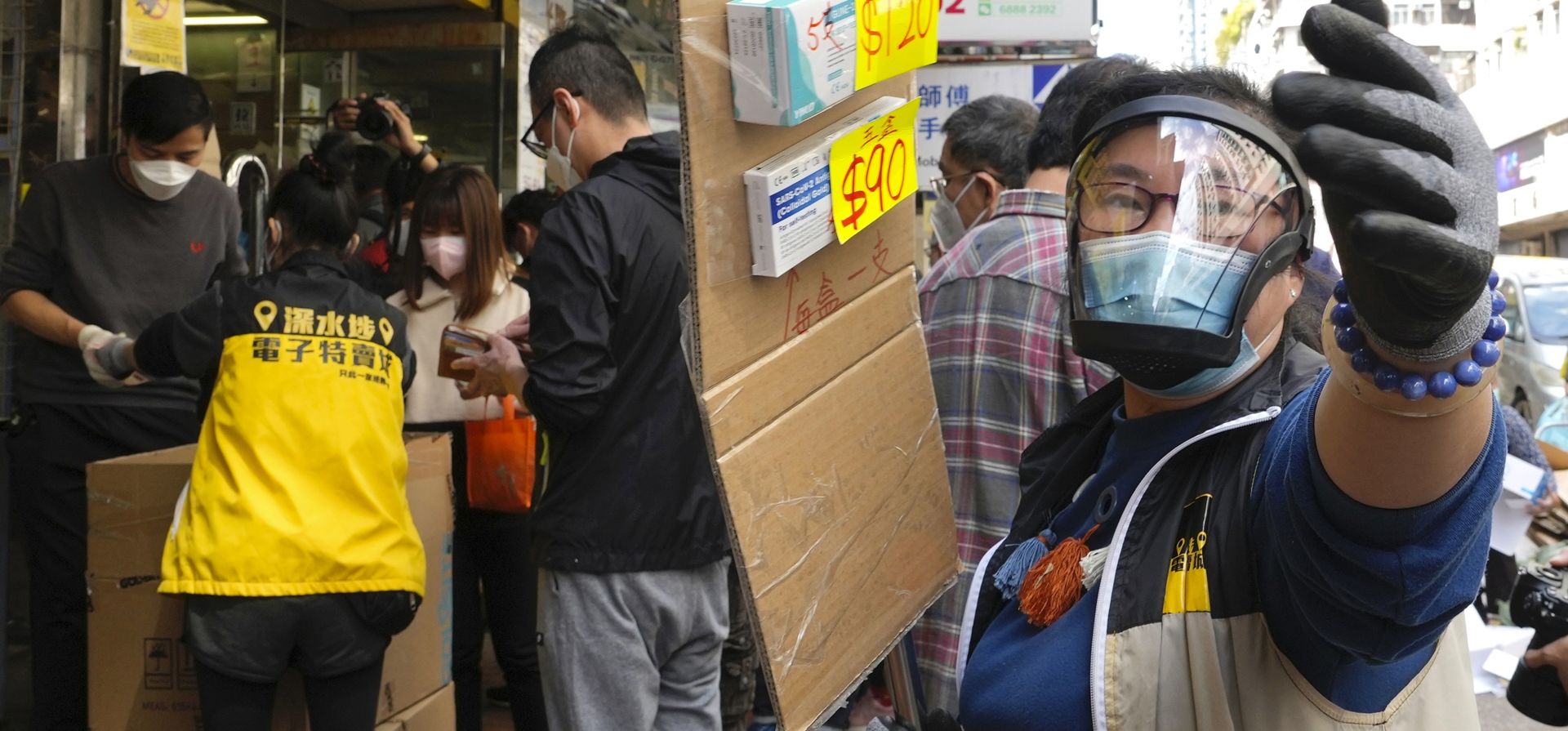 Un vendedor sostiene un cartón con los precios de los kits de prueba de antígeno COVID-19 en un mercado de Hong Kong, el lunes 28 de febrero de 2022.