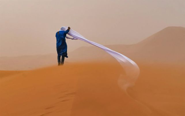 Un guía en el desierto del Sahara soporta una tormenta de arena.