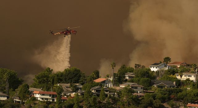 Se arroja agua sobre las casas a medida que avanza el incendio Palisades en Mandeville Canyon el sábado 11 de enero de 2025 en Los Ángeles. 