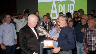 Daniel Tramontini le entrega el trofeo 2025 a los referentes de APUR, el último campeón.
