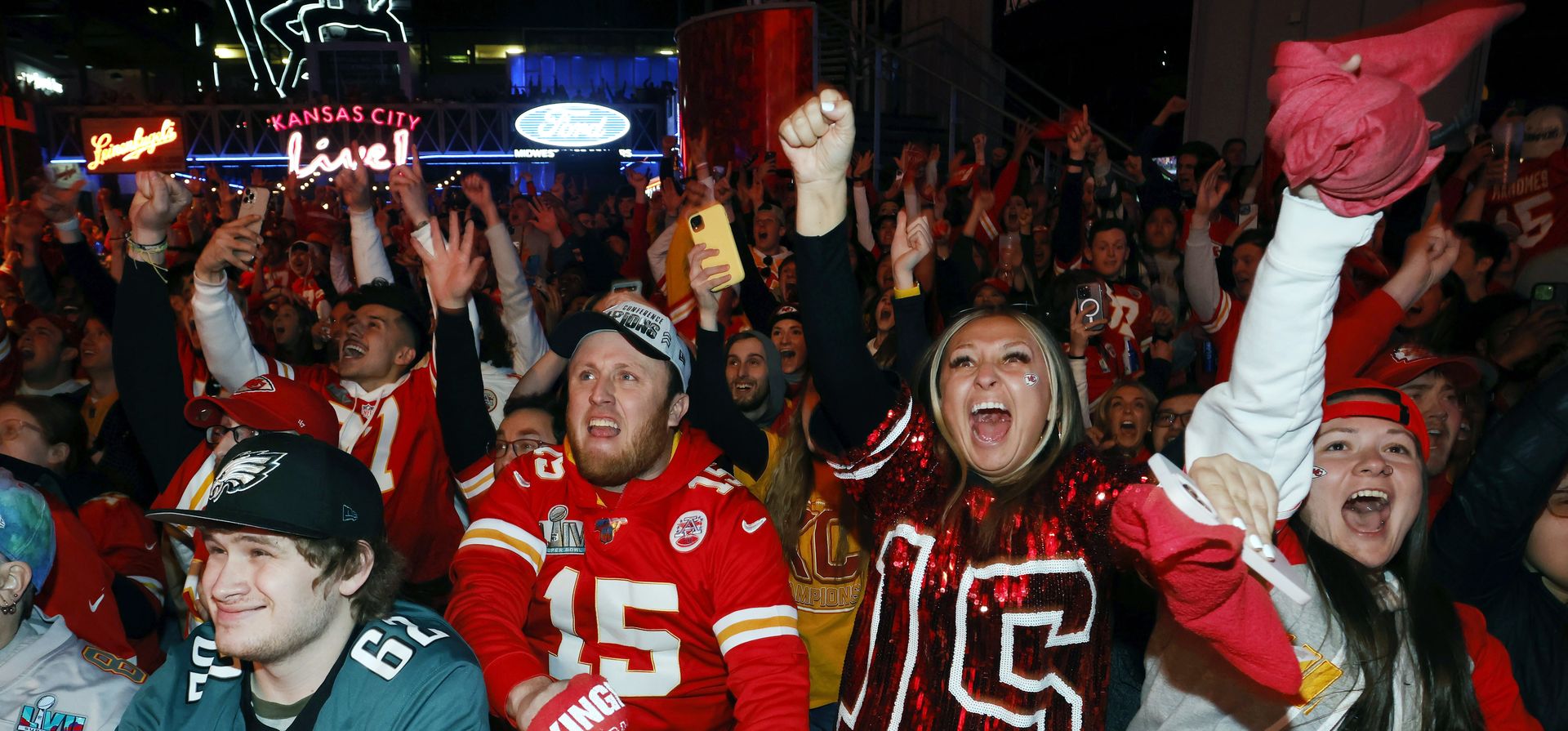 Un fanático de los Philadelphia Eagles, a la izquierda, reacciona cuando los fanáticos de Kansas City celebran un touchdown de los Chiefs durante el partido de fútbol americano NFL Super Bowl 57 en una fiesta en el distrito de entretenimiento Power and Light en Kansas City, Missouri, el domingo 12 de febrero de 2023. (Foto AP/Colin E. Braley)