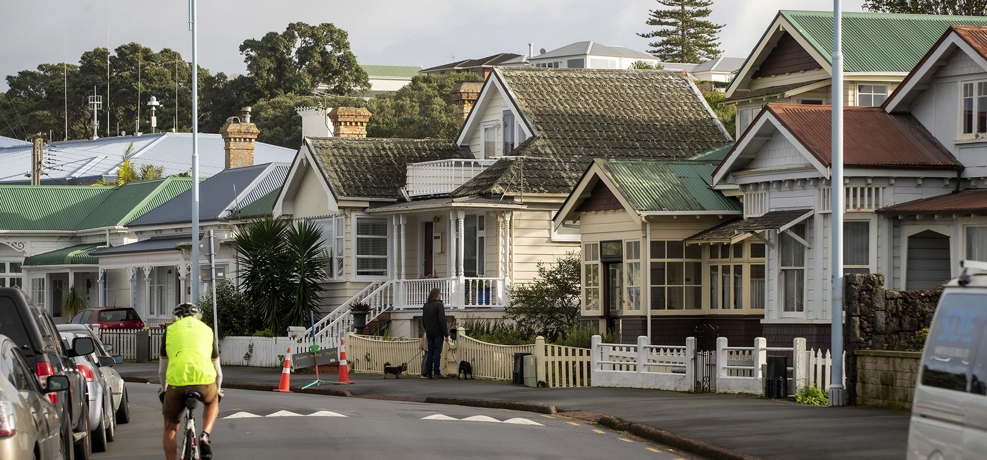 Un hombre pasa en bicicleta por casas en Devonport, suburbio de Auckland, Nueva Zelanda. Un informe muestra que los precios de la vivienda en Nueva Zelanda cayeron por primera vez en más de una década a medida que aumenta el interés las tasas finalmente detuvieron un auge que solo se aceleró después de que golpeó la pandemia de coronavirus.