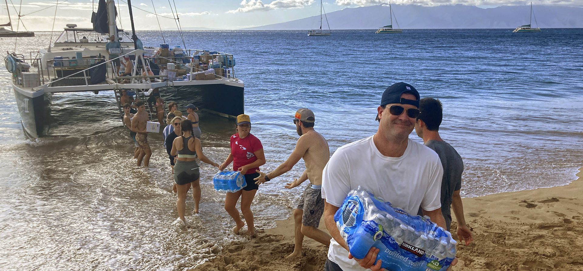 Un grupo de voluntarios forma una línea de montaje en la playa de Kaanapali, Maui, para descargar donaciones de un barco, después de que un mortal incendio forestal ,el pasado agosto, destruyera cientos de hogares y dejara a decenas de personas sin hogar. (Foto AP/Rick Bowmer, archivo) Un grupo de voluntarios forma una línea de montaje en la playa de Kaanapali, Maui, para descargar donaciones de un barco, después de que un mortal incendio forestal ,el pasado agosto, destruyera cientos de hogares y dejara a decenas de personas sin hogar. (Foto AP/Rick Bowmer, archivo)