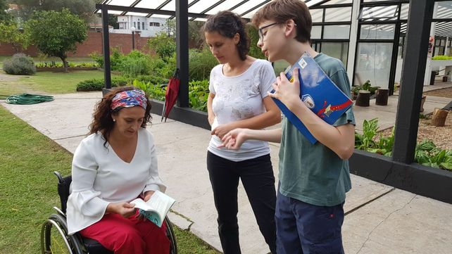 Michetti repasa el material literario de Santino. En la foto acompaña la madre del pequeño paranaense.
