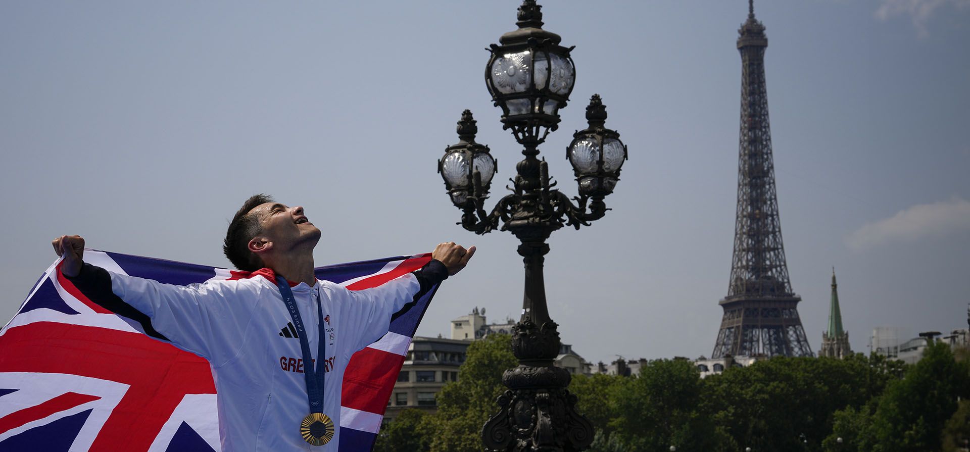 El medallista de oro británico Alex Yee sostiene la bandera británica al final de la ceremonia de entrega de medallas de la competencia individual masculina de triatlón en los Juegos Olímpicos de Verano de 2024, el miércoles 31 de julio de 2024, en París, Francia. (Foto AP/Dar Yasin) El medallista de oro británico Alex Yee sostiene la bandera británica al final de la ceremonia de entrega de medallas de la competencia individual masculina de triatlón en los Juegos Olímpicos de Verano de 2024, el miércoles 31 de julio de 2024, en París, Francia. (Foto AP/Dar Yasin)