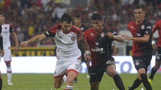 La pelea. Nacho Scocco intenta maniobrar ante la marca mexicana. Newells fue superado por Atlas en Guadalajara.