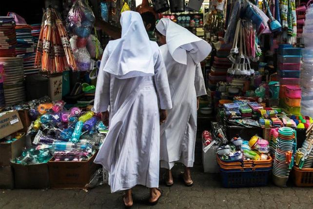 Monjas buscan artículos para el hogar en una tienda cerca del mercado de Crawford en Mumbai