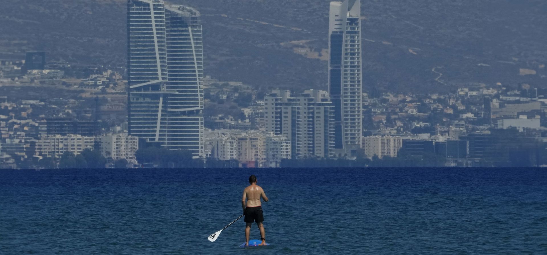 Un hombre disfruta de un cálido día practicando paddleboard en el mar frente a las torres de la ciudad costera de Limassol, Chipre, el jueves 26 de septiembre de 2024. (Foto AP/Petros Karadjias) Un hombre disfruta de un cálido día practicando paddleboard en el mar frente a las torres de la ciudad costera de Limassol, Chipre, el jueves 26 de septiembre de 2024. (Foto AP/Petros Karadjias)
