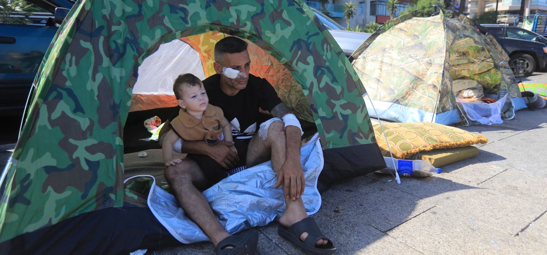 Beirut, Líbano Un desplazado herido se sienta con su hijo dentro de su tienda en el paseo marítimo de Ain al-Mreisseh. Los intensos ataques israelíes obligaron a cerca de un millón de personas a huir de partes del Líbano en lo que posiblemente sea la peor crisis de desplazamiento en la historia del país Fotografía: AFP/Getty Images Beirut, Líbano Un desplazado herido se sienta con su hijo dentro de su tienda en el paseo marítimo de Ain al-Mreisseh. Los intensos ataques israelíes obligaron a cerca de un millón de personas a huir de partes del Líbano en lo que posiblemente sea la peor crisis de desplazamiento en la historia del país Fotografía: AFP/Getty Images