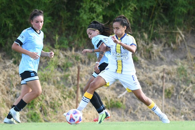 Paula Salguero maniobra ante dos futbolistas de Belgrano.