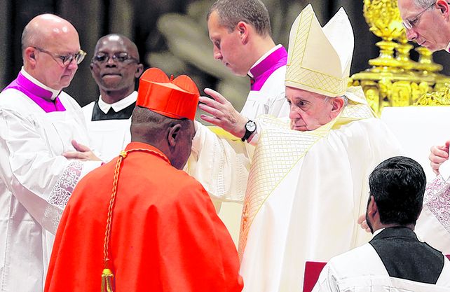Diversidad. El Papa posa el birrete cardenalicio sobre el congoleño Fridolin Among Besungu.