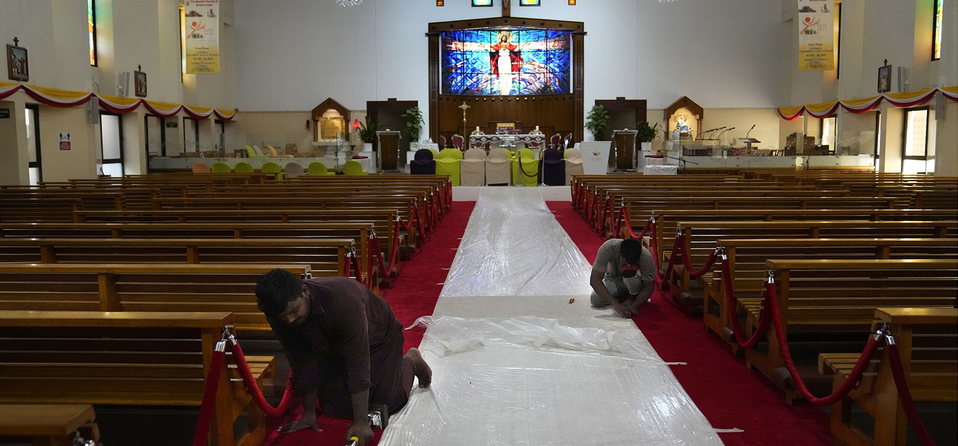 Trabajadores ajustan una alfombra roja en la iglesia del Sagrado Corazón donde visitará el Papa Francisco, en Manama, Bahréin, el miércoles 2 de noviembre de 2022. El Papa Francisco realizará la visita del 3 al 6 de noviembre para participar en una conferencia patrocinada por el gobierno sobre Oriente -Diálogo occidental.