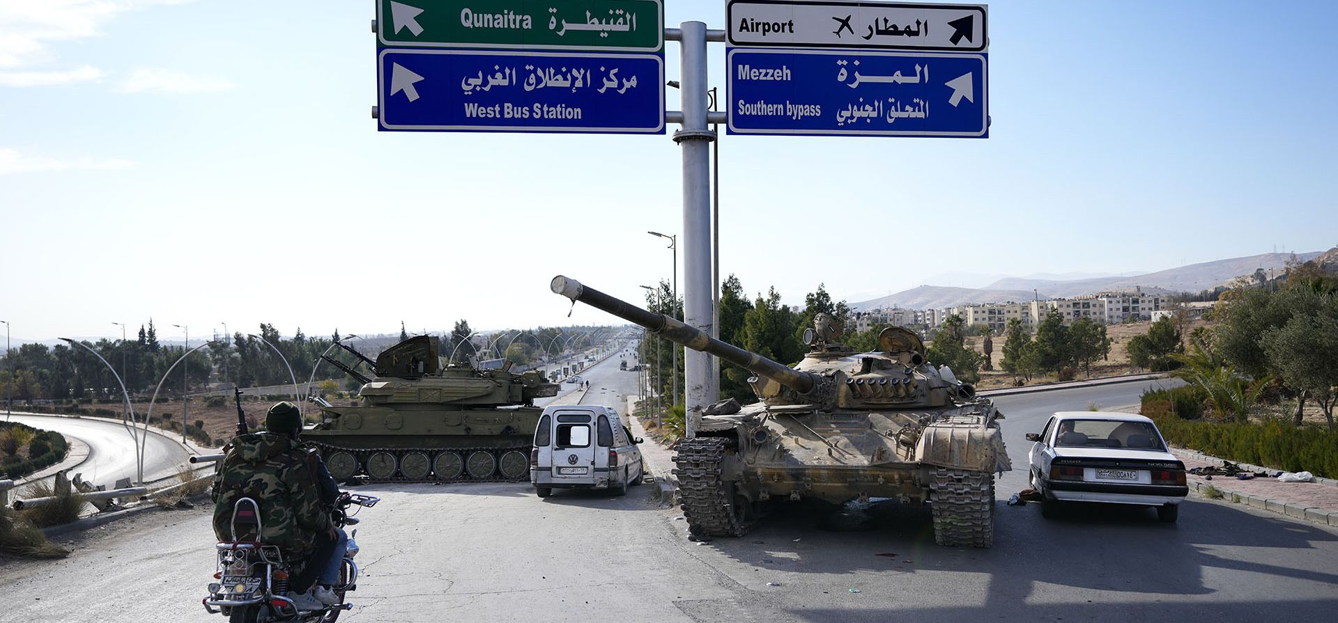 Los combatientes de la oposición pasan junto a tanques de las fuerzas gubernamentales que quedaron abandonados en una carretera en Damasco, Siria, el domingo 8 de diciembre de 2024. (Foto AP/Hussein Malla) Los combatientes de la oposición pasan junto a tanques de las fuerzas gubernamentales que quedaron abandonados en una carretera en Damasco, Siria, el domingo 8 de diciembre de 2024. (Foto AP/Hussein Malla)