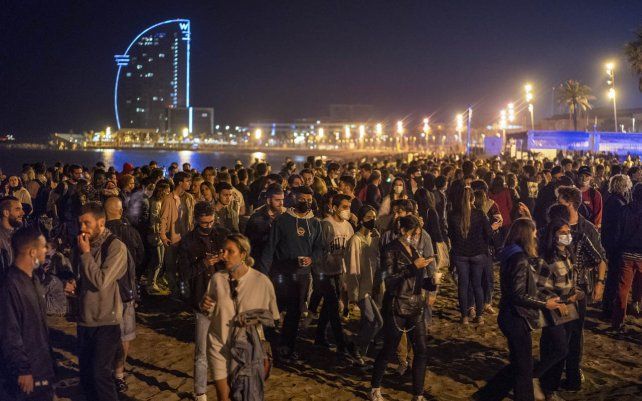 La gente se agolpó en la playa de Barcelona, España, el domingo 9 de mayo de 2021. Los residentes de Barcelona estaban eufóricos cuando el reloj dio la medianoche, poniendo fin a un estado de emergencia nacional de seis meses de duración, y en consecuencia, al toque de queda local.