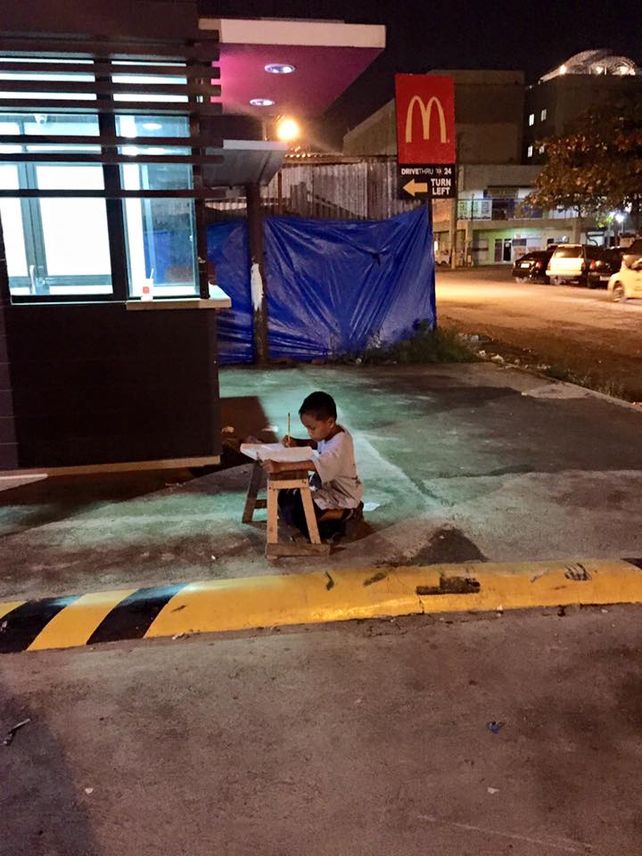 La foto de niño que estudia en la calle por falta de luz en su casa es viral