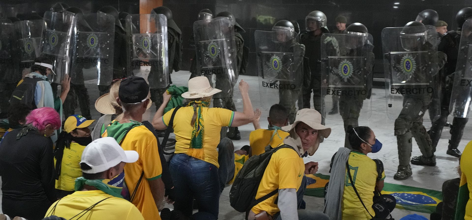 Manifestantes, simpatizantes del expresidente brasileño Jair Bolsonaro, se enfrentan a policías antidisturbios después de que irrumpieron en el Palacio de Planalto en Brasilia, Brasil, el domingo 8 de enero de 2023. (Foto AP/Eraldo Peres)
