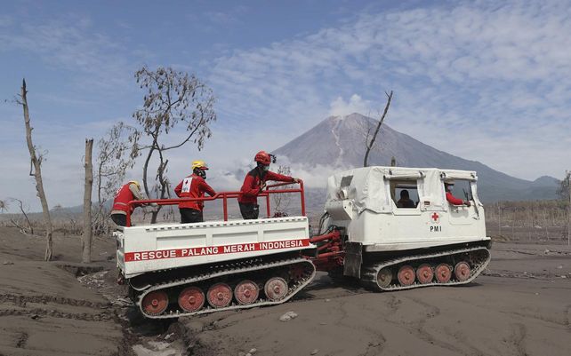 Rescatistas viajan en un vehículo todoterreno durante la búsqueda de víctimas de la erupción del monte Semeru, al fondo, en Lumajang, Java Oriental, Indonesia, el miércoles 8 de diciembre de 2021. Fuertes lluvias y torrentes de lava caliente y barro resbalando por el El volcán en erupción de la isla de Java suspendió las operaciones de búsqueda y rescate de más de una docena de desaparecidos, dijeron las autoridades. Foto: AP 