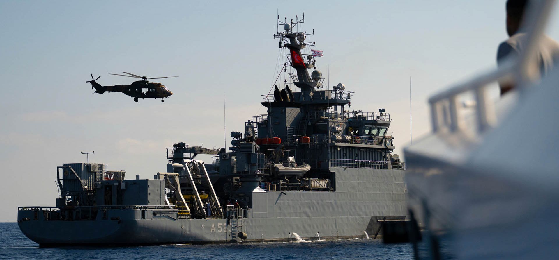 Un barco y un helicóptero turcos participan en una operación de búsqueda de personas desaparecidas dos días después del desastre de un ferry frente a la costa de Chipre, cerca del puerto de Kyrenia en la parte norte de Chipre ocupada por Turquía, el martes 1 de septiembre de 2026. (Foto AP/Nedim Enginsoy)