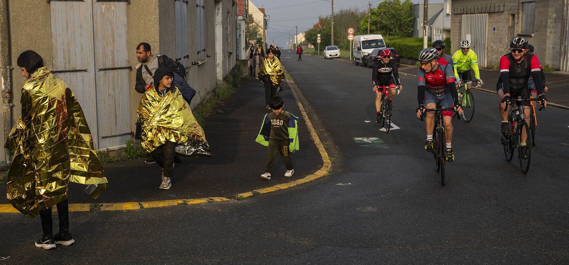 Mientras pasan ciclistas, un grupo de inmigrantes kurdos de Irán e Irak que no tuvieron éxito en su intento de llegar al Reino Unido en barco caminan de regreso a la ciudad de Ambleteuse en el norte de Francia, el domingo 19 de mayo de 2024, después de ser descubiertos por la policía. (Foto AP/Bernat Armangue) Mientras pasan ciclistas, un grupo de inmigrantes kurdos de Irán e Irak que no tuvieron éxito en su intento de llegar al Reino Unido en barco caminan de regreso a la ciudad de Ambleteuse en el norte de Francia, el domingo 19 de mayo de 2024, después de ser descubiertos por la policía. (Foto AP/Bernat Armangue)