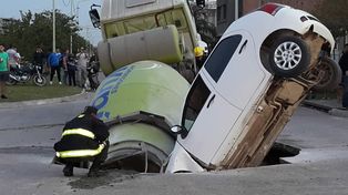 Un auto y un camión fueron tragados por un inmenso pozo en plena calle