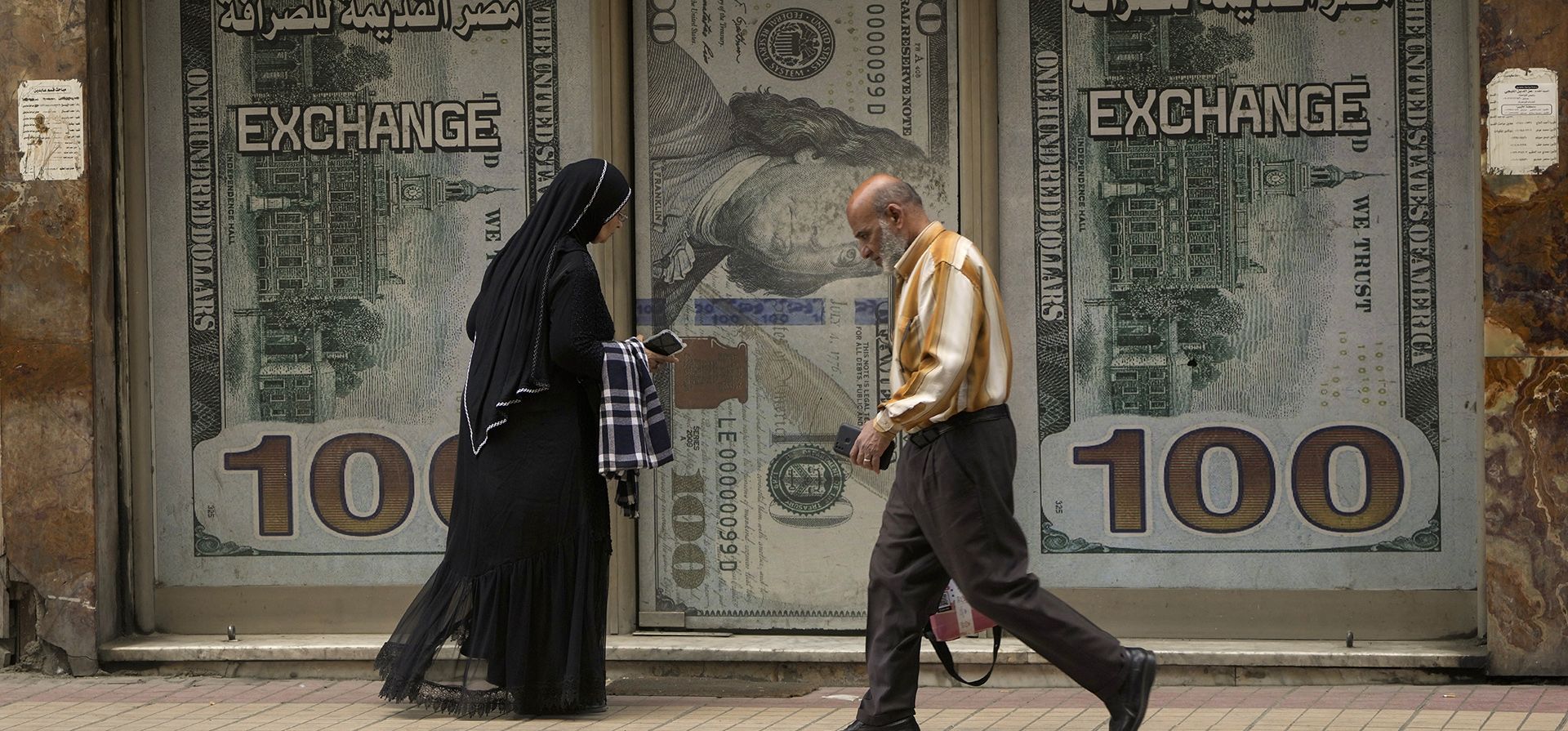 Los egipcios pasan por una oficina de cambio en El Cairo, Egipto, el miércoles 6 de marzo de 2024. La libra egipcia cayó bruscamente frente al dólar el miércoles después de que el Banco Central de Egipto elevó su principal tasa de interés y dijo que permitiría que el tipo de cambio de la moneda fuera fijado por las fuerzas del mercado. (Foto AP/Amr Nabil) Los egipcios pasan por una oficina de cambio en El Cairo, Egipto, el miércoles 6 de marzo de 2024. La libra egipcia cayó bruscamente frente al dólar el miércoles después de que el Banco Central de Egipto elevó su principal tasa de interés y dijo que permitiría que el tipo de cambio de la moneda fuera fijado por las fuerzas del mercado. (Foto AP/Amr Nabil)